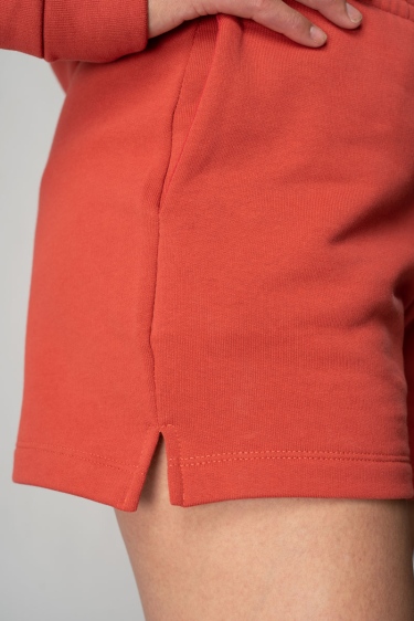 Sweatshorts "Kiba" aus Bio-Baumwolle in orange-rot Detail von Seitenschlitz